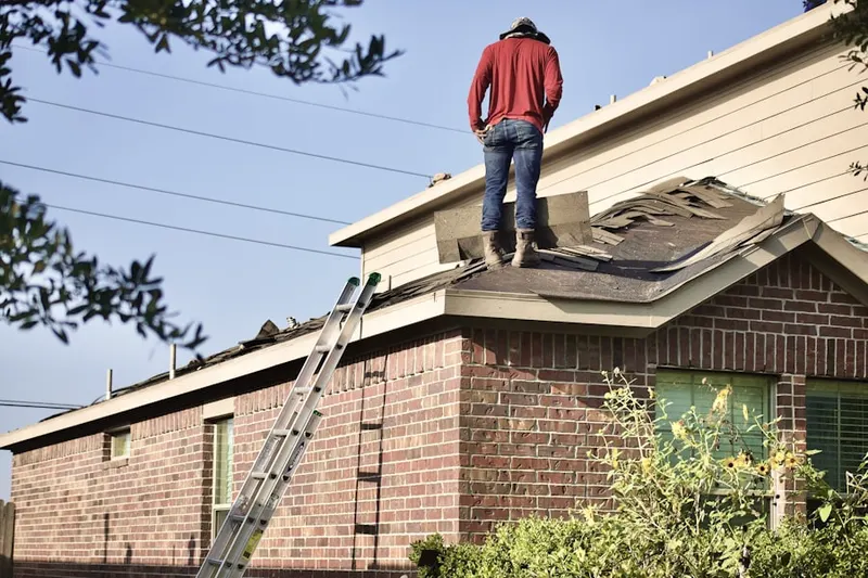 Professional roofer working on a residential roof in West Leominster